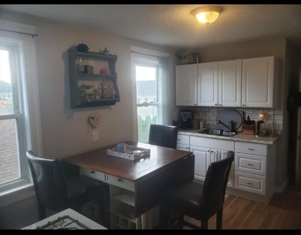 a kitchen with a table chairs and window