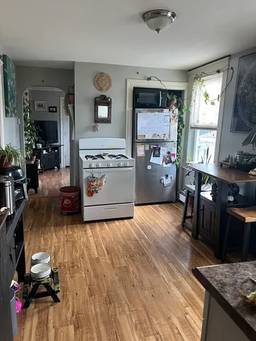 a kitchen with furniture and a wooden floor