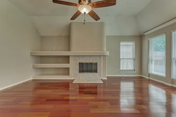a view of a livingroom with a chandelier fan and windows
