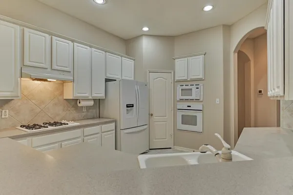 a white refrigerator freezer and a stove sitting inside of a kitchen