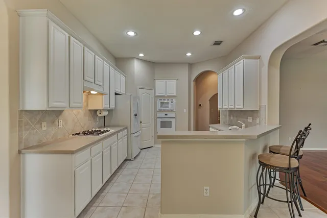 a kitchen with stainless steel appliances granite countertop a sink and cabinets
