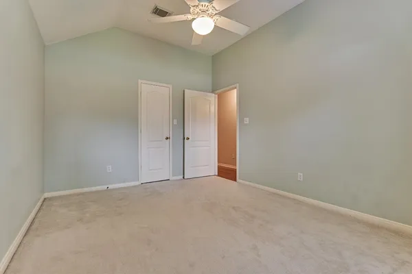 an empty room with closet and a chandelier fan