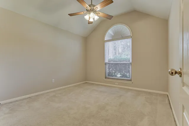 an empty room with closet and a chandelier fan