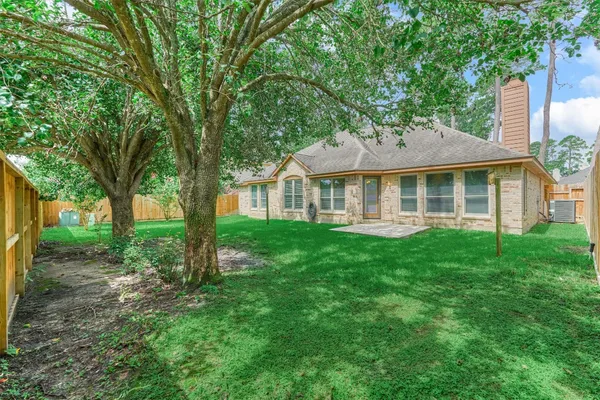 a view of a backyard with a trees and wooden fence