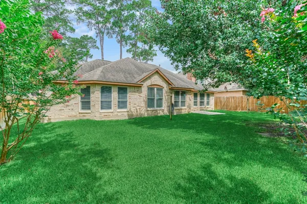 a front view of a house with a yard and green space