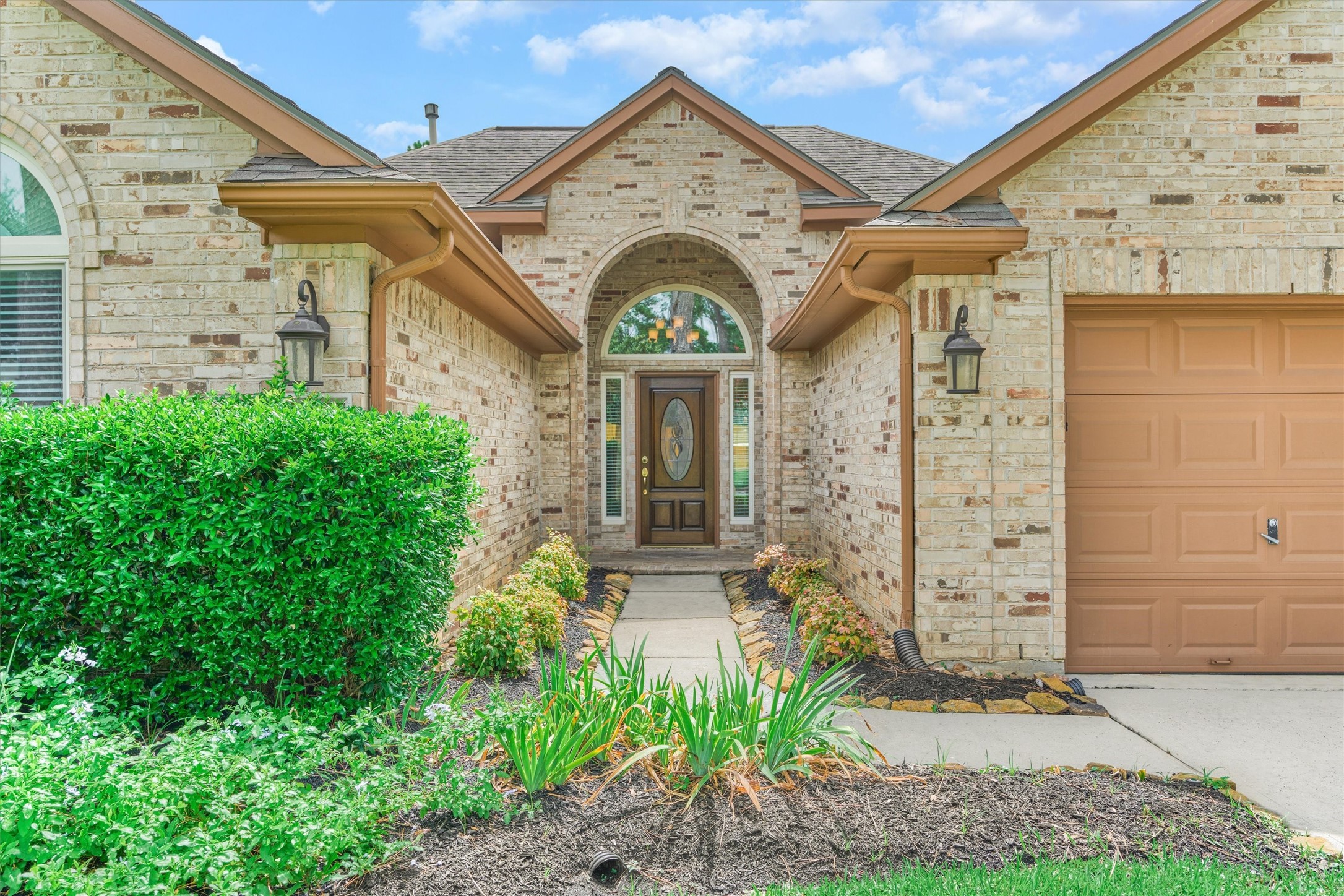 930 Arbor Pine Tomball, TX 77375 - Photo 7 of 45 a view of a brick house with potted plants and a large tree