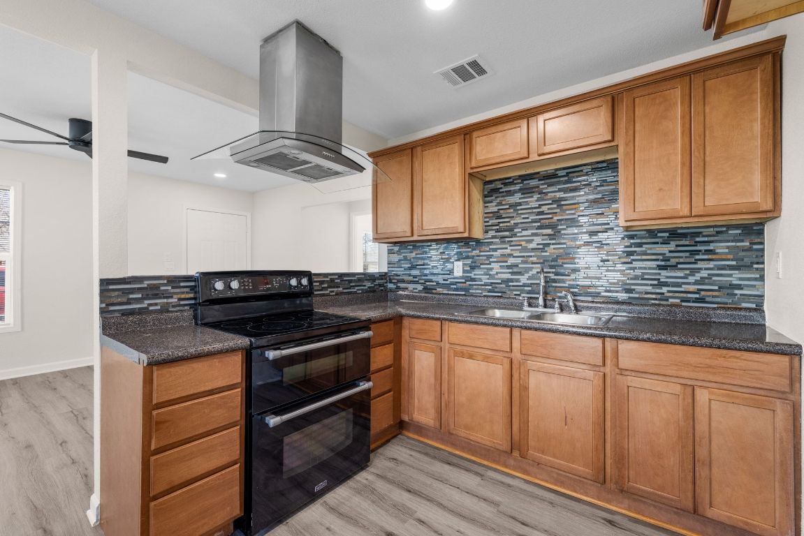 1308 South 45th Street Temple, TX 76504 - Photo 8 of 26 Kitchen with range with two ovens, decorative backsplash, brown cabinetry, and recessed lighting