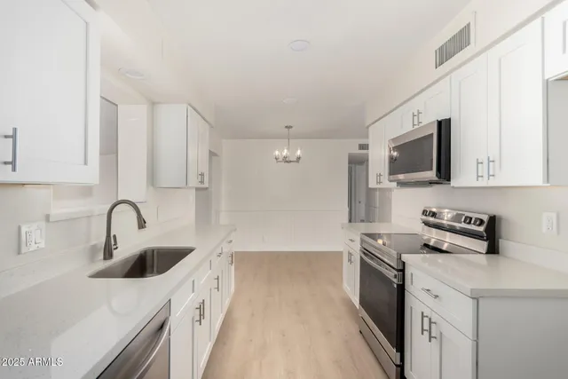 a kitchen with a sink a stove and cabinets