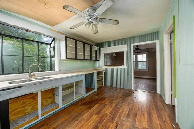 a view of a kitchen with a sink and dishwasher with wooden floor
