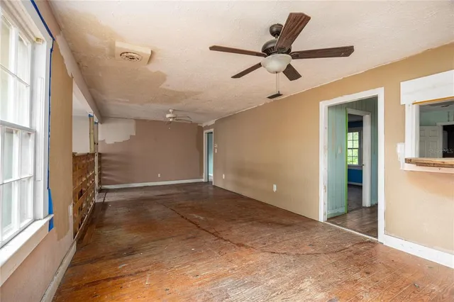 a view of empty room with stairs and a ceiling fan