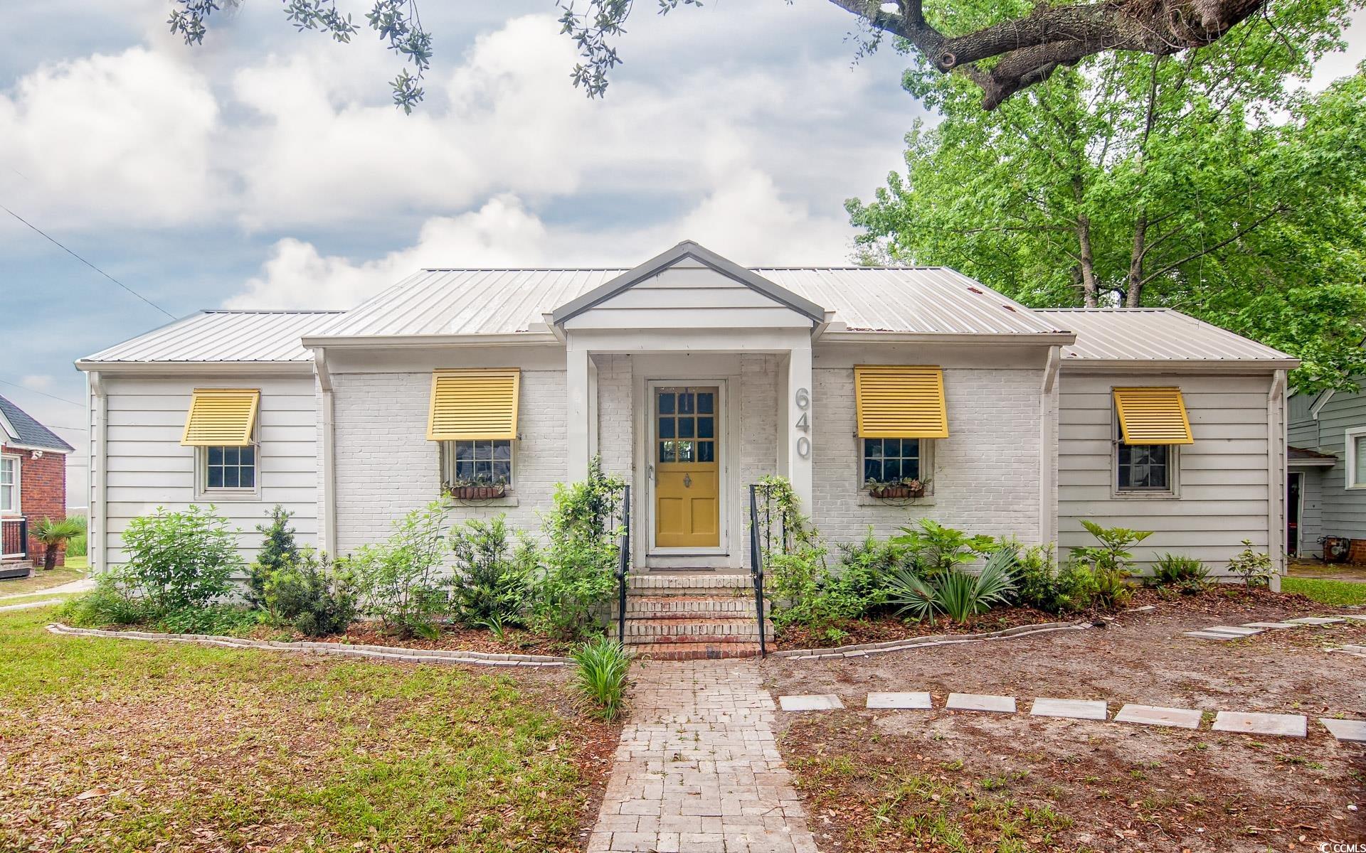 Bungalow with metal roof and brick siding