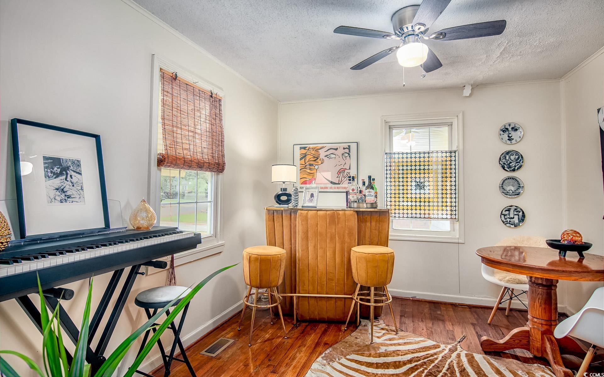 640 Willow Bank Road Georgetown, SC 29440 - Photo 9 of 18 Living area with healthy amount of natural light, a textured ceiling, wood finished floors, baseboards, and crown molding