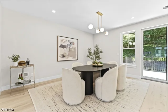 a dining room with chandelier and wooden floor