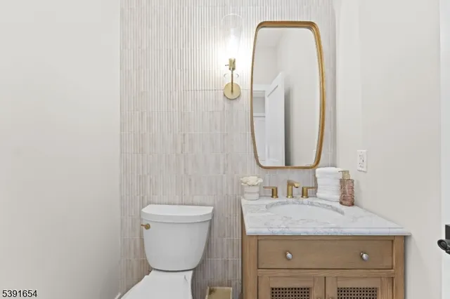 a bathroom with a granite countertop toilet sink and mirror