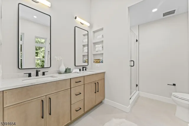 a bathroom with double vanity sinks and a mirror