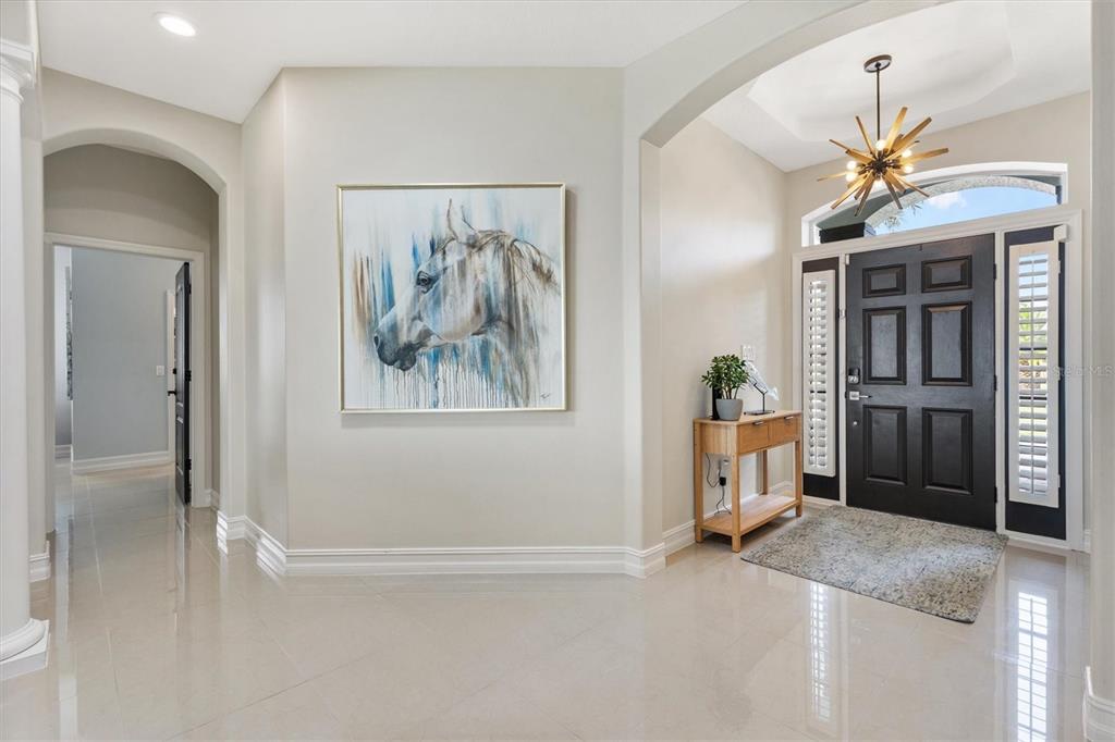 12114 Eagle Point Court Leesburg, FL 34788 - Photo 6 of 39 a view of a hallway with a chandelier fan and windows
