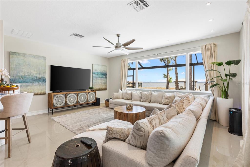 12114 Eagle Point Court Leesburg, FL 34788 - Photo 10 of 39 a living room with furniture a large window and a flat screen tv