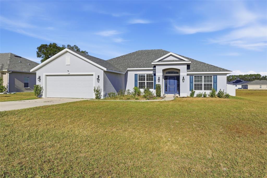 9144 Southeast 47th Court Road Ocala, FL 34480 - Photo 4 of 32 a front view of a house with a yard and garage