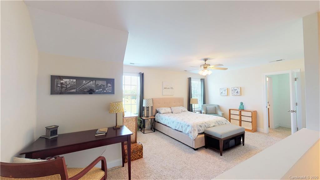3812 Zebulon Williams Road Monroe, NC 28110 - Photo 21 of 31 a bedroom with a bed and a chandelier