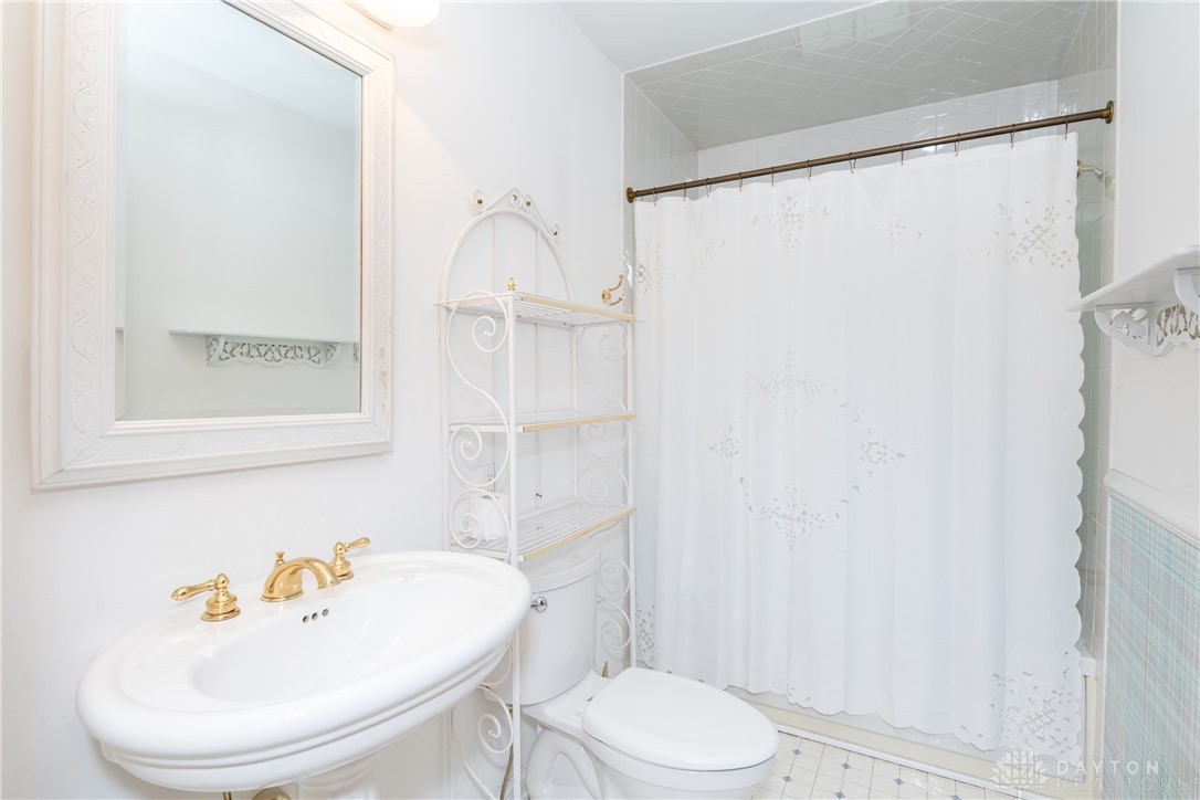 9981 Ridge Acres Lane Englewood, OH 45322 - Photo 23 of 73 This bright bathroom features elegant brass fixtures and a clean, classic design.