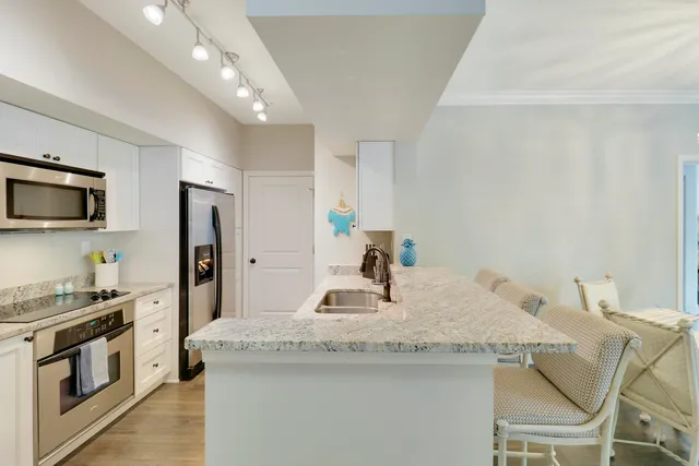 a kitchen with stainless steel appliances granite countertop a sink a stove and a refrigerator