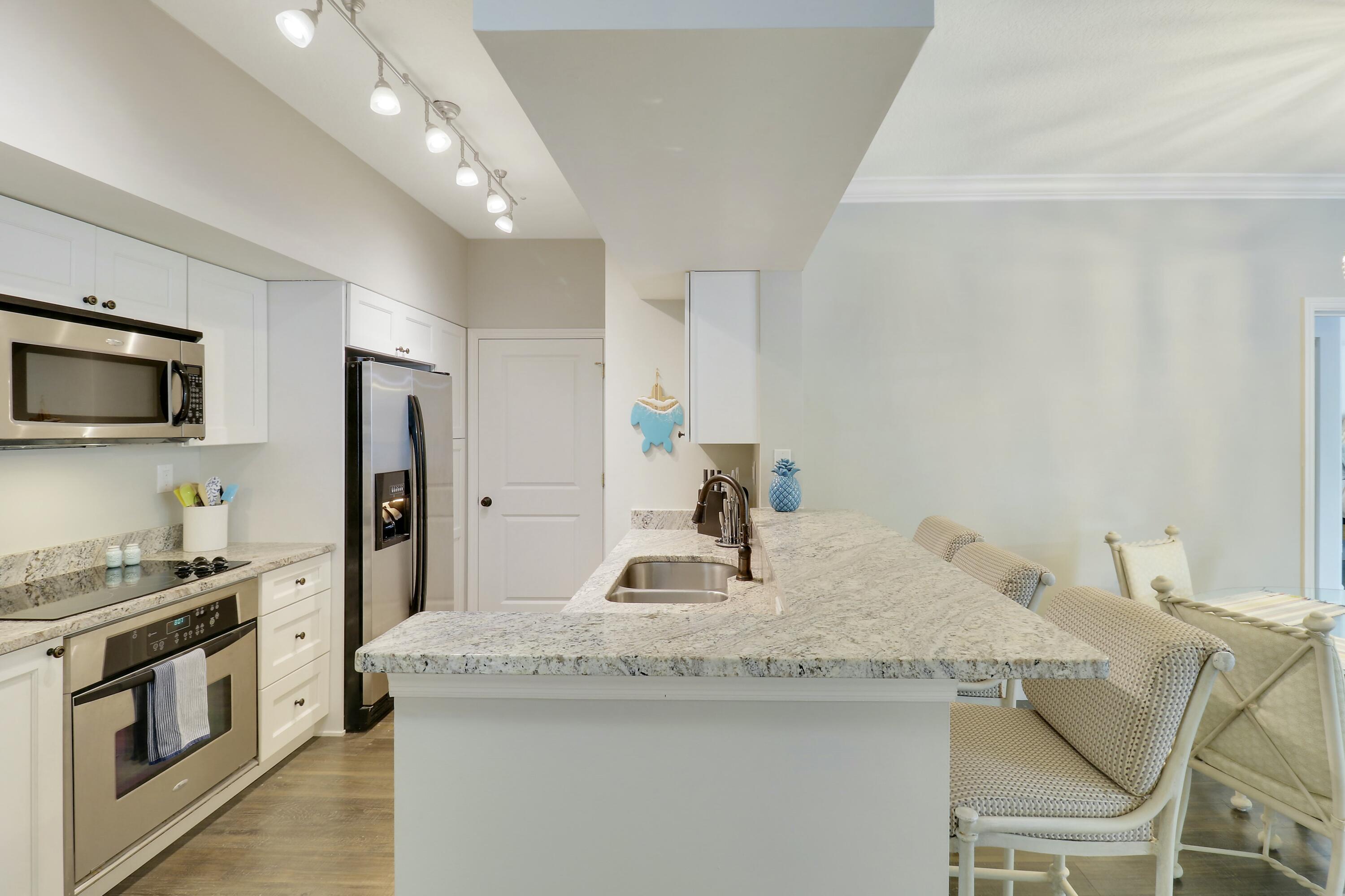 215 Northwest Flagler Avenue, Unit 301 Stuart, FL 34994 - Photo 11 of 34 a kitchen with stainless steel appliances granite countertop a sink a stove and a refrigerator