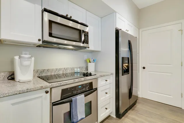 a kitchen with stainless steel appliances granite countertop a stove microwave and sink
