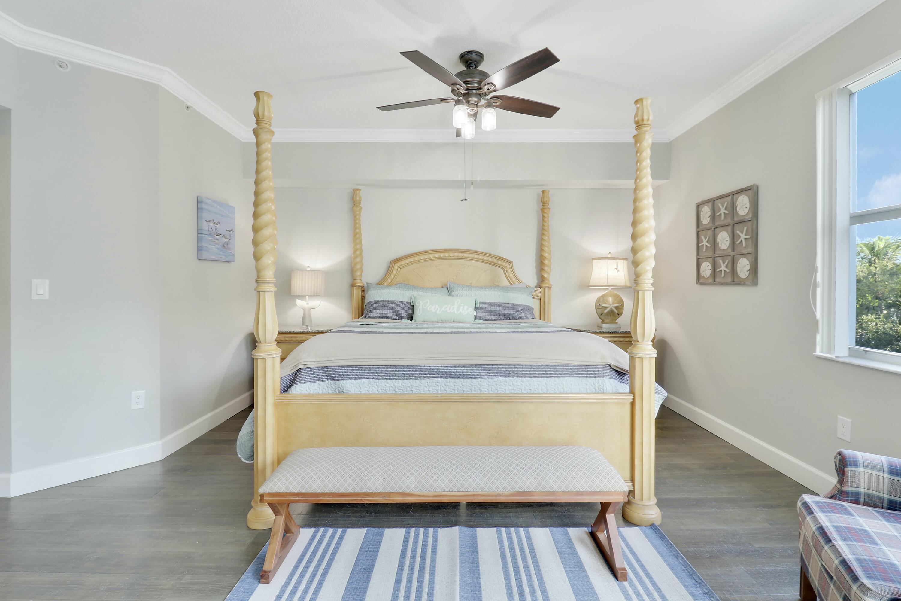 215 Northwest Flagler Avenue, Unit 301 Stuart, FL 34994 - Photo 24 of 34 a bedroom with a bed and wooden floor