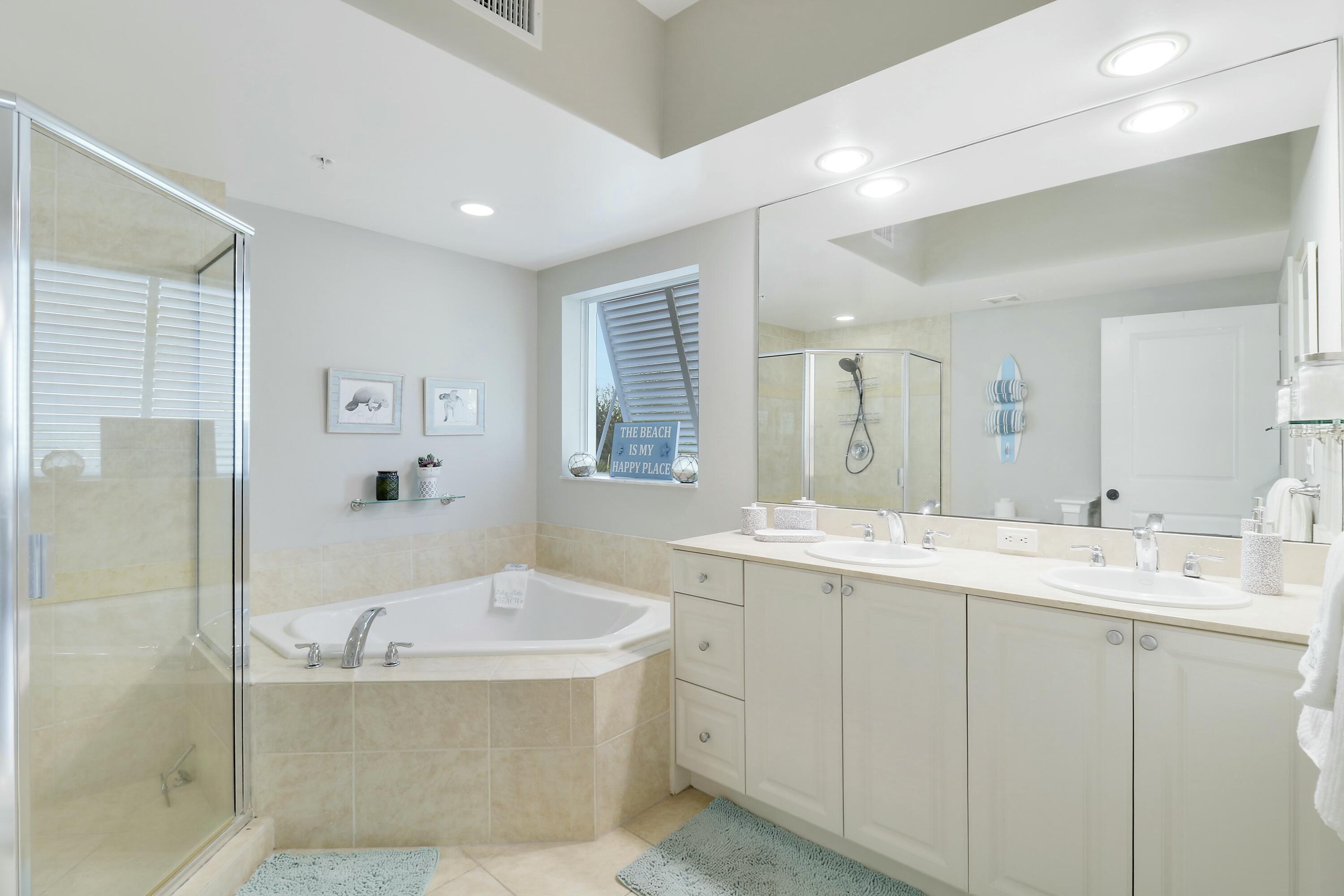 215 Northwest Flagler Avenue, Unit 301 Stuart, FL 34994 - Photo 26 of 34 a bathroom with a tub a sink and mirror