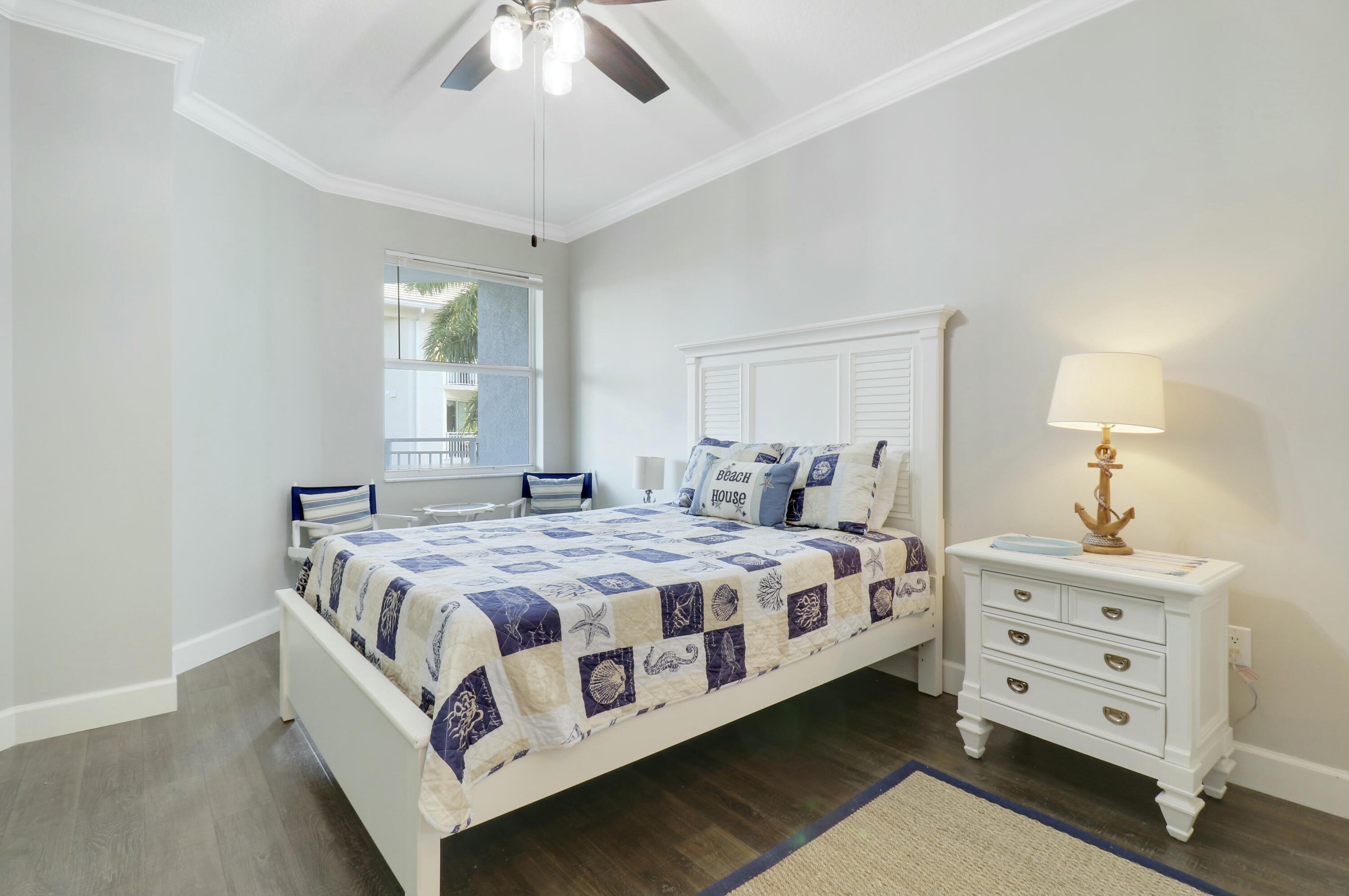 215 Northwest Flagler Avenue, Unit 301 Stuart, FL 34994 - Photo 27 of 34 a bedroom with a bed and a dresser