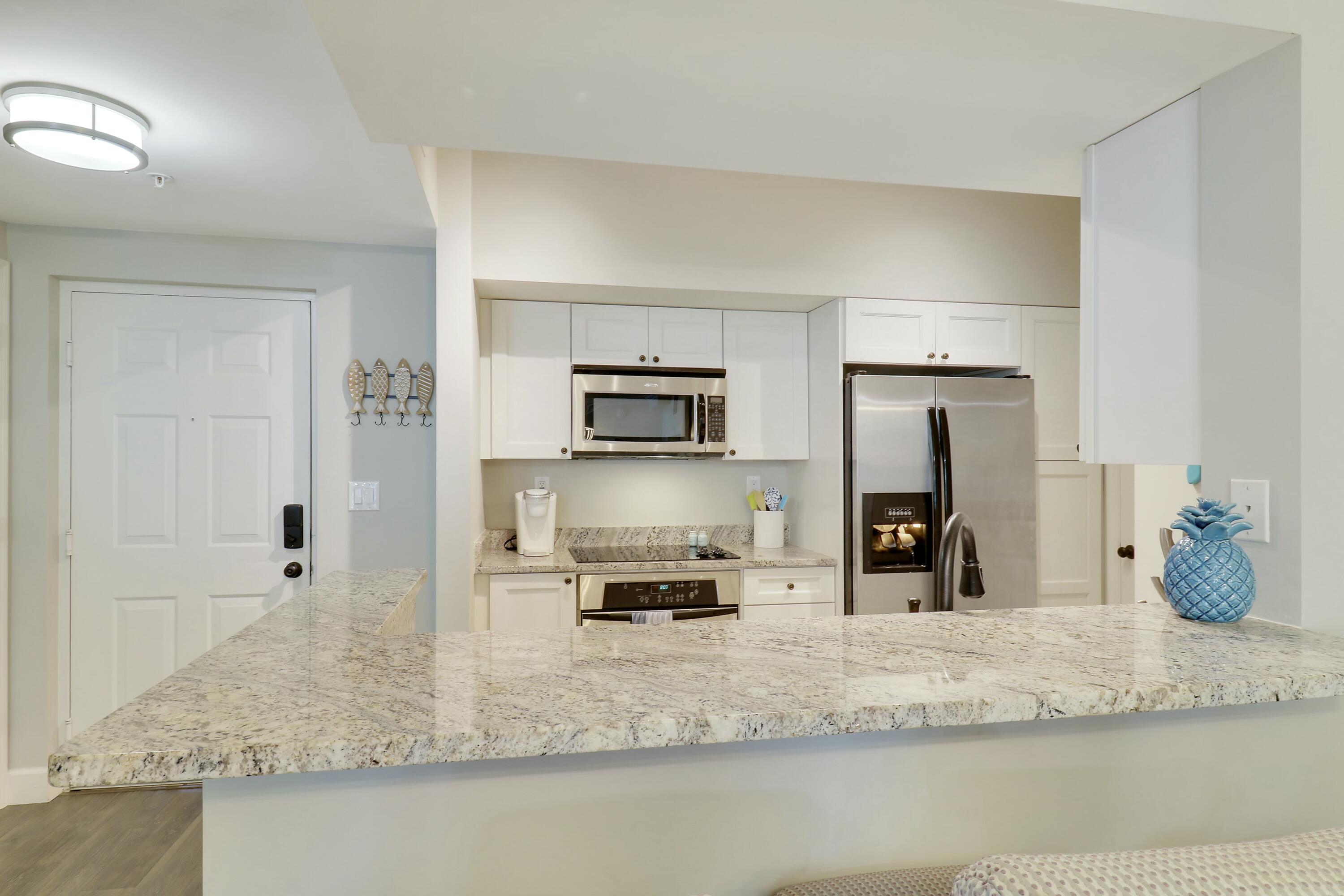 215 Northwest Flagler Avenue, Unit 301 Stuart, FL 34994 - Photo 10 of 34 a view of a kitchen with kitchen island a counter top space and stainless steel appliances