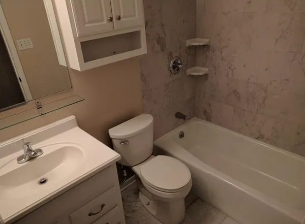a white toilet sitting next to a bath tub