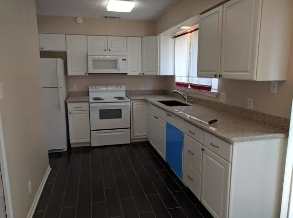 a kitchen with a stove a sink and a refrigerator