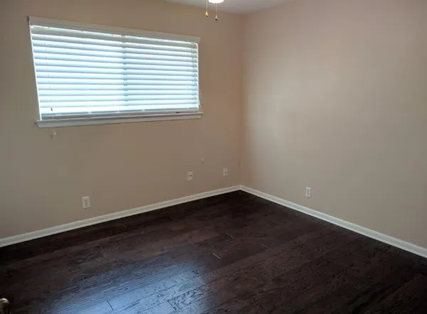 an empty room with wooden floor and a window