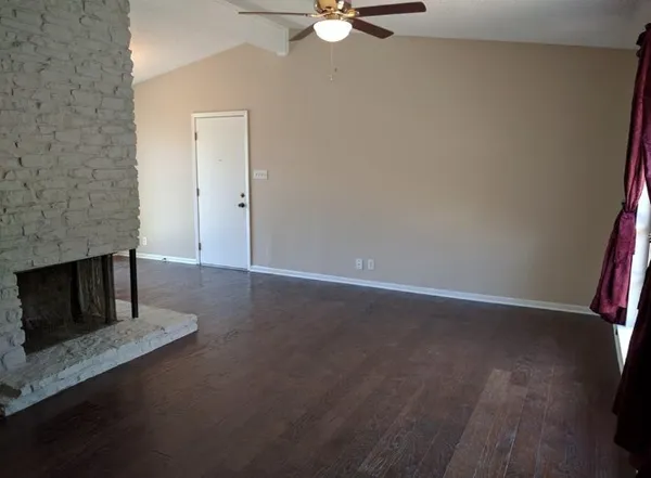 an empty room with a fireplace and fan