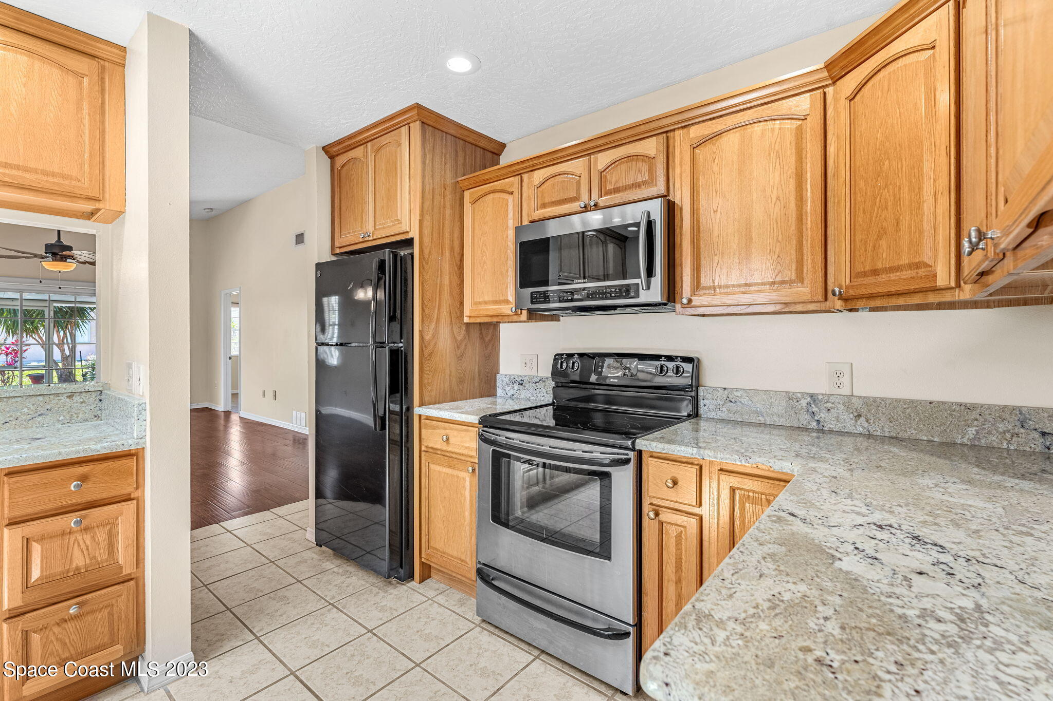 840 Cross Lake Drive Melbourne, FL 32901 - Photo 11 of 63 a kitchen with stainless steel appliances granite countertop a stove a microwave and a refrigerator