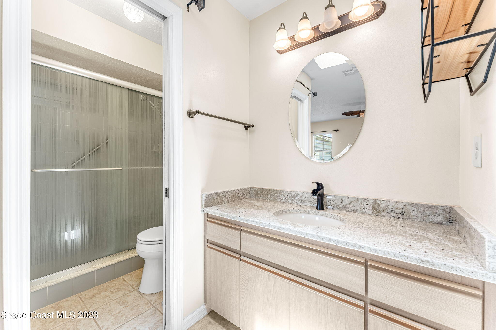 840 Cross Lake Drive Melbourne, FL 32901 - Photo 25 of 63 a bathroom with a granite countertop sink a toilet and a mirror