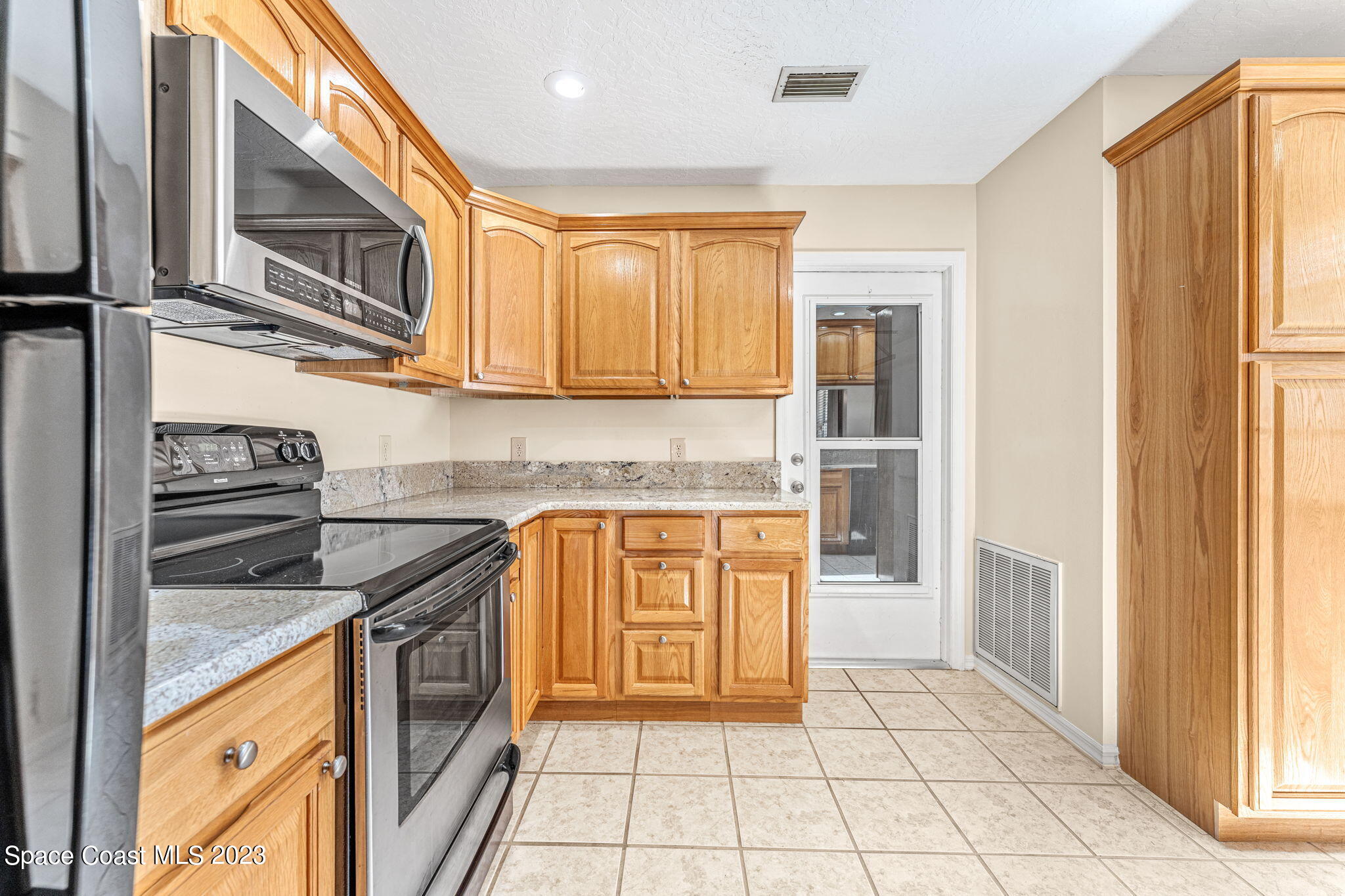 840 Cross Lake Drive Melbourne, FL 32901 - Photo 9 of 63 a kitchen with stainless steel appliances granite countertop a stove a sink and a microwave
