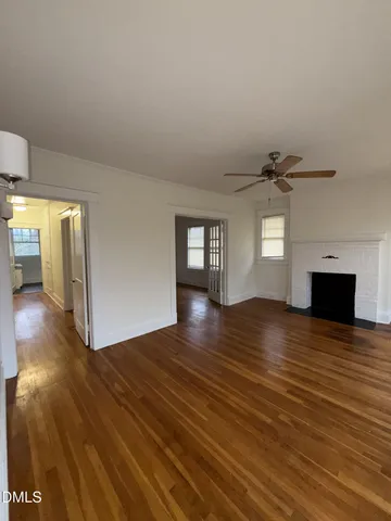 a view of empty room with wooden floor and fireplace