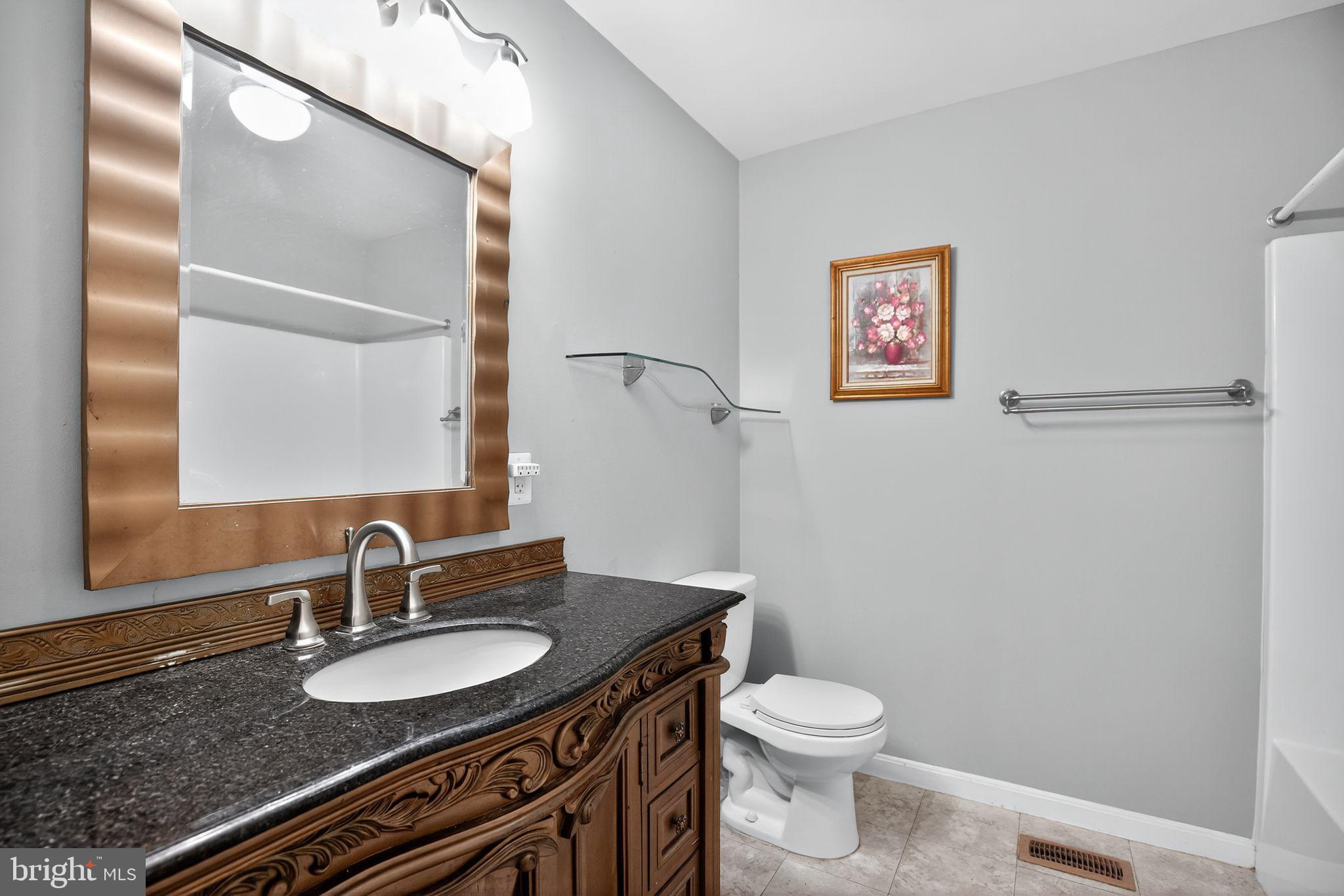 7726 Wills Lane Fort Washington, MD 20744 - Photo 21 of 30 a bathroom with a granite countertop sink toilet and mirror