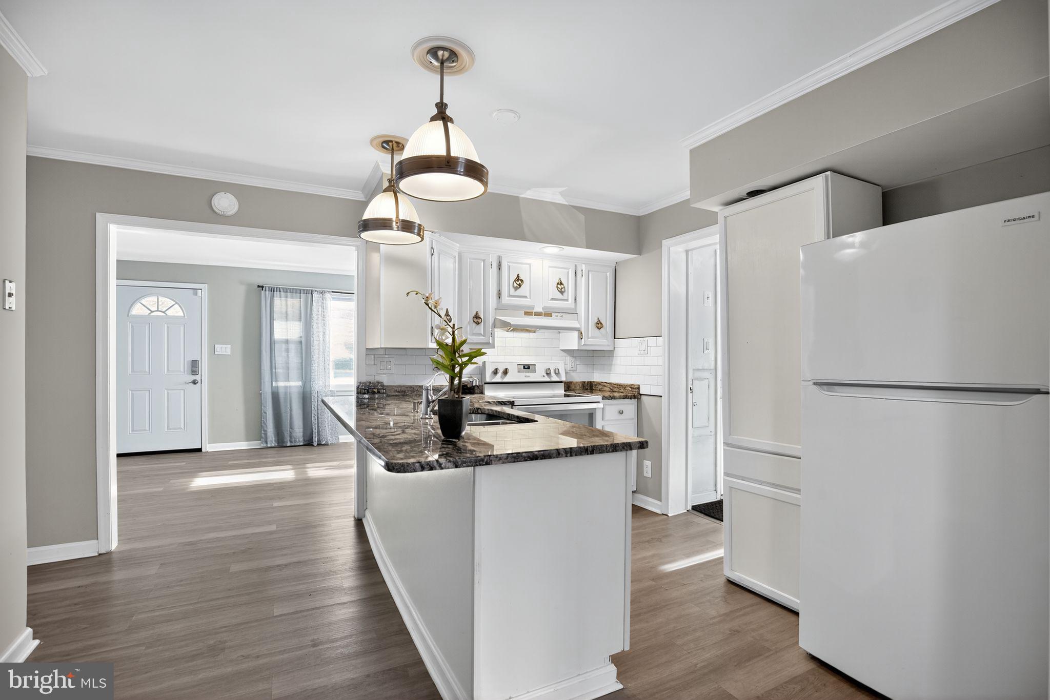 7726 Wills Lane Fort Washington, MD 20744 - Photo 6 of 30 a kitchen with a refrigerator a sink and dishwasher with wooden floor