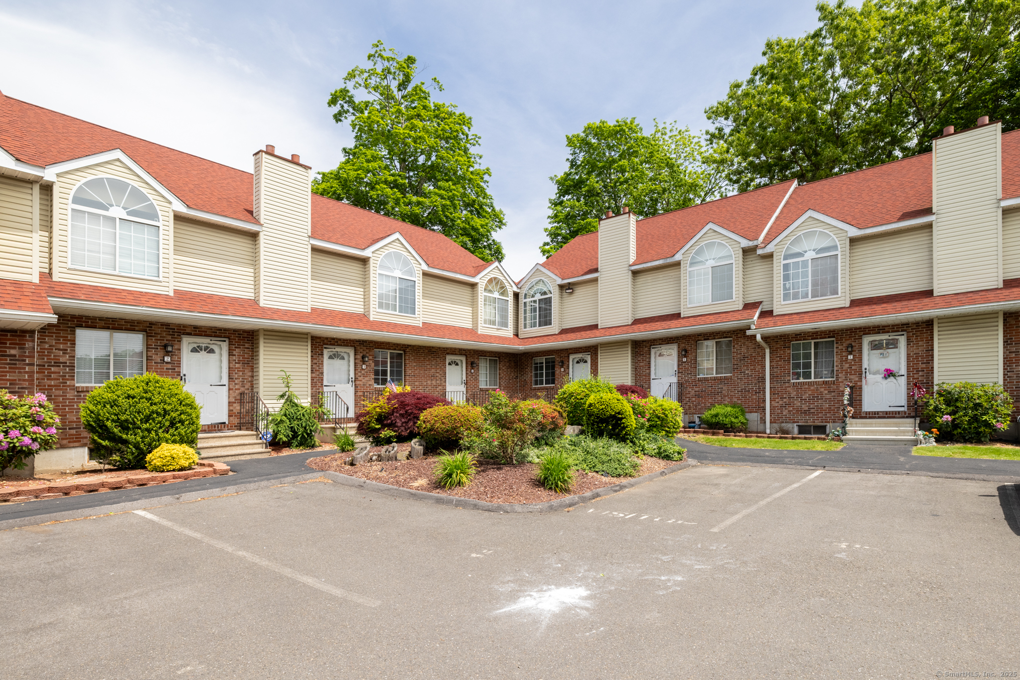 78 Pierpont Road, Unit 5 Waterbury, CT 06705 - Photo 1 of 1 a front view of a building with a yard and potted plants