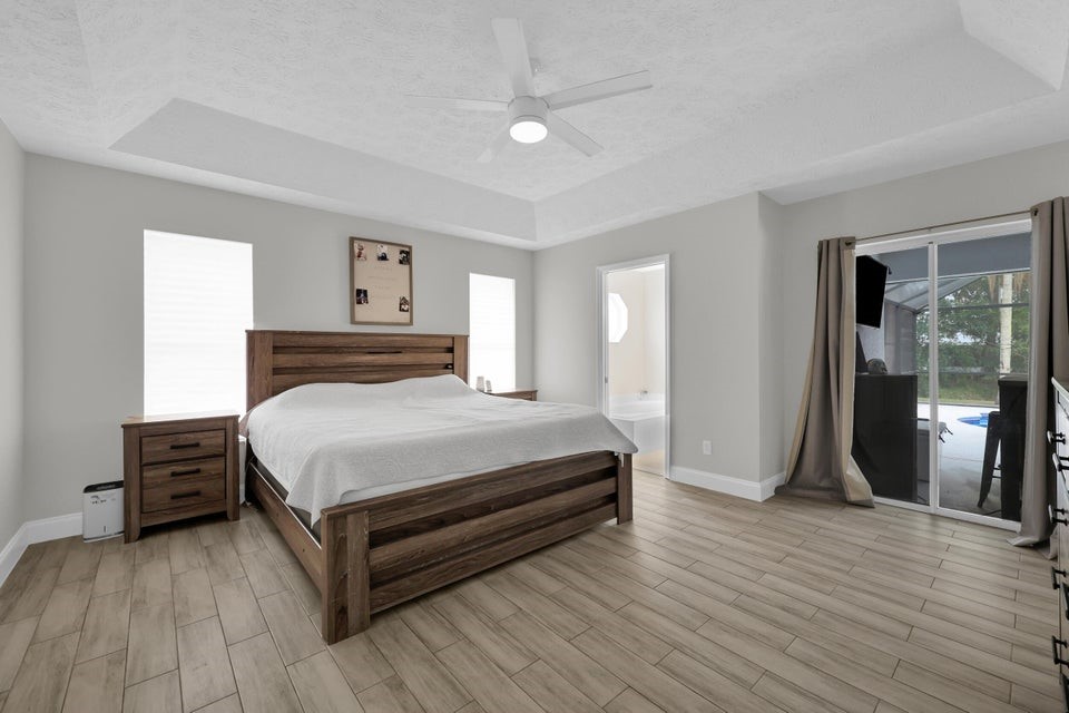 1950 Southwest Logwood Road Port St. Lucie, FL 34953 - Photo 14 of 32 a bedroom with a bed and wooden floor