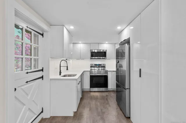 a kitchen with stainless steel appliances a refrigerator sink and stove