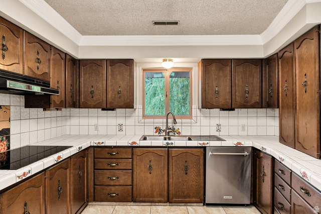 1365 Sumac Drive Logan, UT 84321 - Photo 19 of 66 U-shaped kitchen featuring wood cabinetry, white tiled countertops, white square tile backsplash, and a stainless steel dishwasher