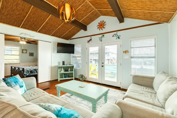 a bedroom with a bed a dresser next to a window