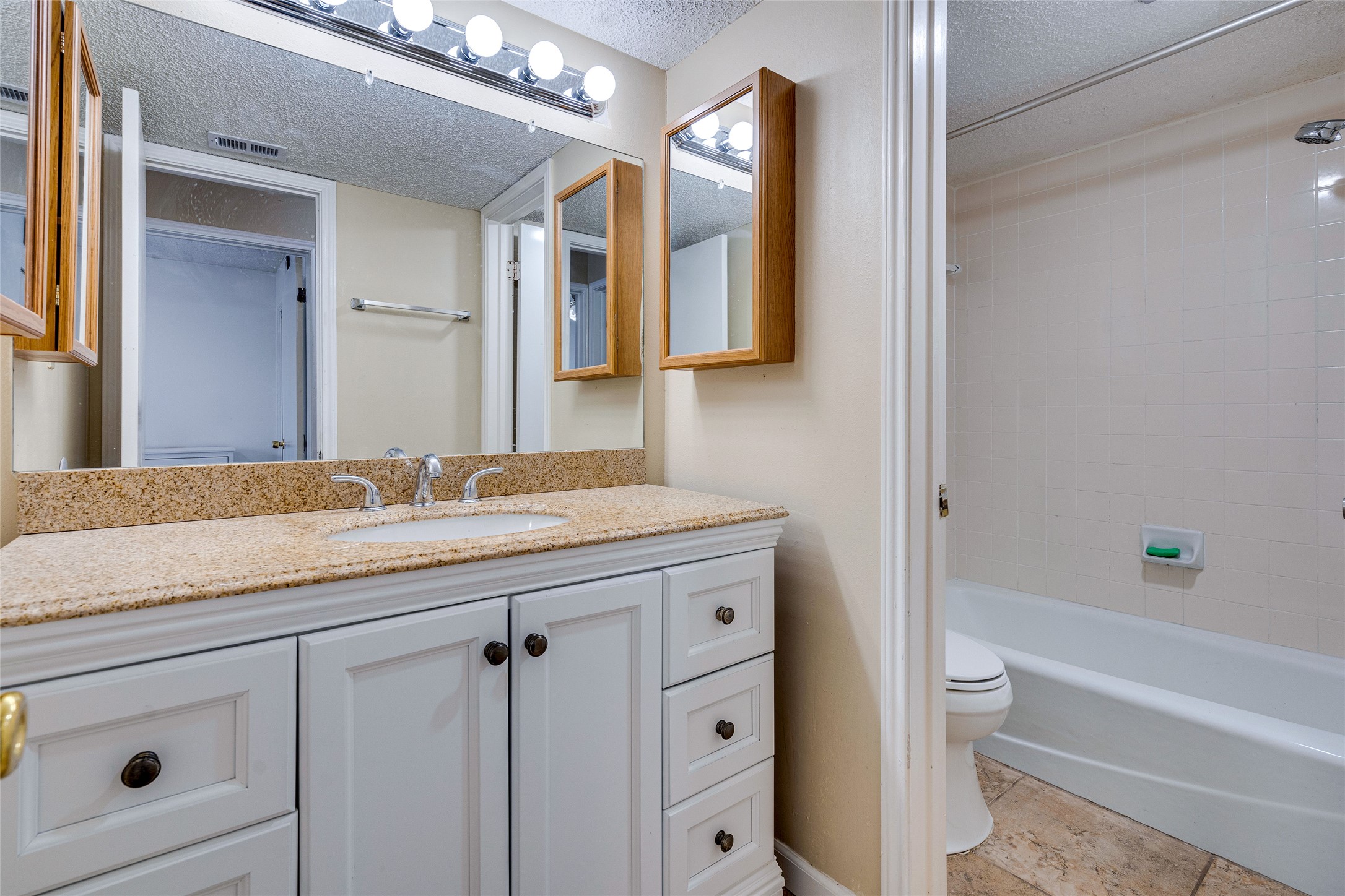 1808 Rio Grande Street, Unit 6 Austin, TX 78701 - Photo 20 of 29 Bathroom featuring vanity, a textured ceiling, and shower combination