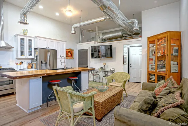 a living room with furniture a flat screen tv and kitchen view