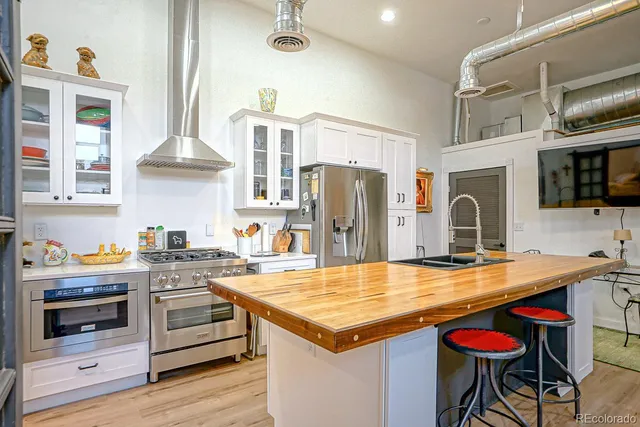 a kitchen with stainless steel appliances granite countertop a stove and a refrigerator