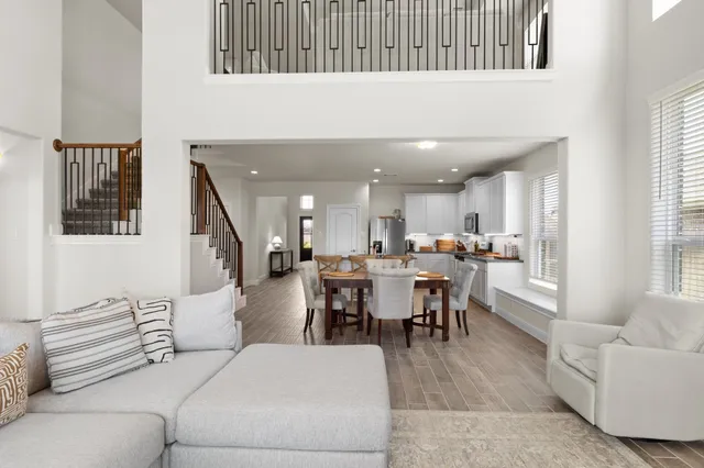 a living room with furniture and a dining table with wooden floor